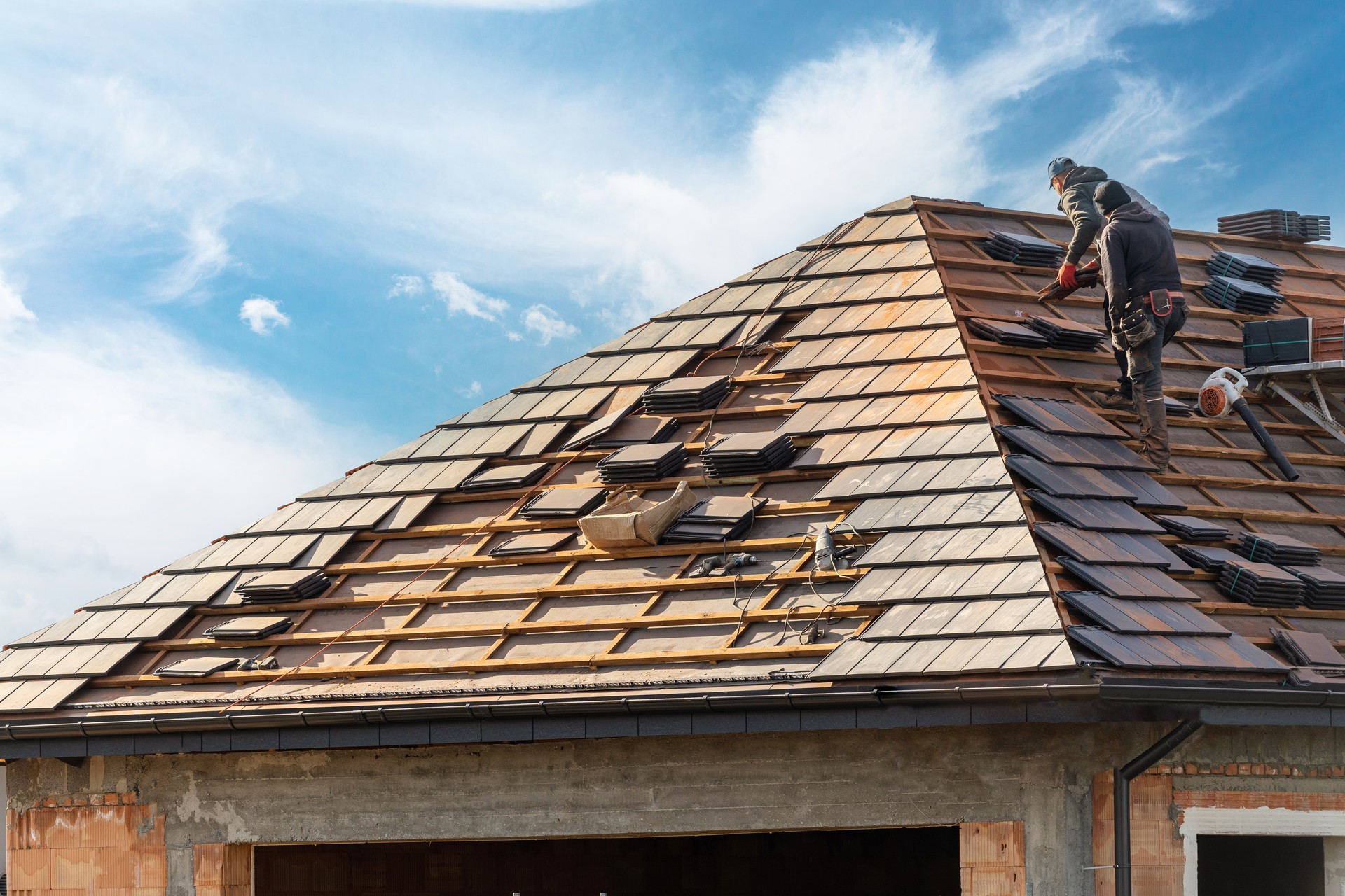 builder working on rooftop of house on construction site